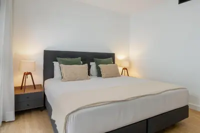 a bedroom with a large white bed with two lamps at Apartamento São Lucas I by An Island Apart in Funchal