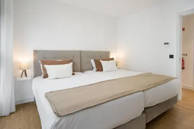 a bedroom with a large bed with white sheets and pillows at Apartamento São Lucas I by An Island Apart in Funchal
