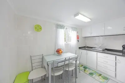 a kitchen with white cabinets and a table and chairs at Peaceful Panorama by YOUR KEY MADEIRA in Porto Moniz