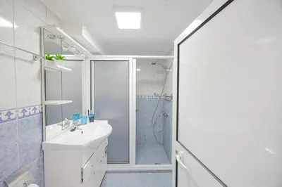 a white bathroom with a shower and a sink at Peaceful Panorama by YOUR KEY MADEIRA in Porto Moniz