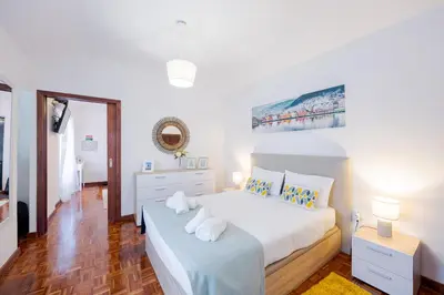 a white bedroom with a bed and a dresser at Peaceful Panorama by YOUR KEY MADEIRA in Porto Moniz