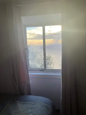 a window in a bedroom with a view of the ocean at Ocean Retreat in Fajã da Ovelha