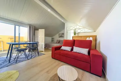 a living room with a red couch and a table at Camarata Flat by Mth in Campanário