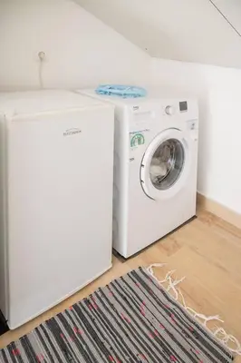 a white washing machine sitting next to a washer at Camarata Flat by Mth in Campanário