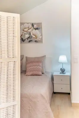 a bedroom with a bed and a table with a lamp at Camarata Flat by Mth in Campanário
