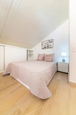 a bedroom with a large bed in a white room at Camarata Flat by Mth in Campanário