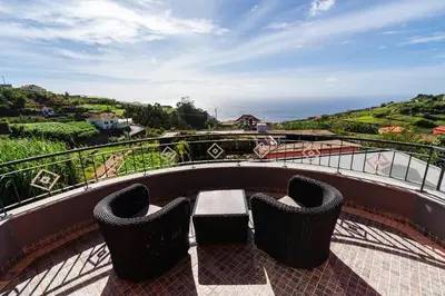a balcony with two chairs and a table on a roof at Casa Fontes in Canhas