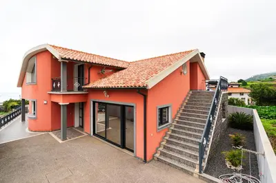a orange house with a staircase in front of it at Casa Fontes in Canhas