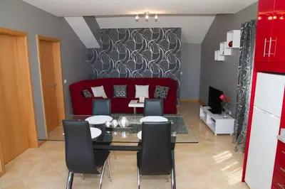 a living room with a dining table and a red couch at Lovely place for an excellent vacation in Arco da Calheta