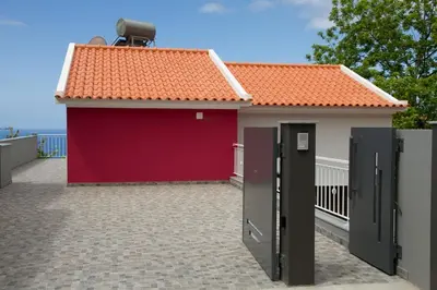a red garage with a red roof on a building at Lovely place for an excellent vacation in Arco da Calheta