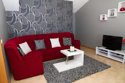 a living room with a red couch and a tv at Lovely place for an excellent vacation in Arco da Calheta
