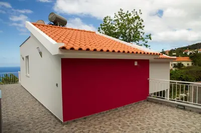 a detached garage with a red garage door at Lovely place for an excellent vacation in Arco da Calheta