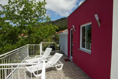 a pair of white chairs on a balcony of a house at Lovely place for an excellent vacation in Arco da Calheta