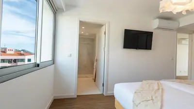 a bedroom with a bed and a window and a tv at Casa do Xano I by LovelyStay in Câmara de Lobos