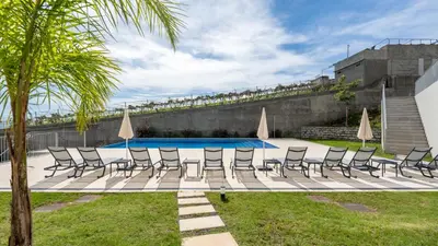 a group of chairs sitting next to a swimming pool at Casa do Xano I by LovelyStay in Câmara de Lobos
