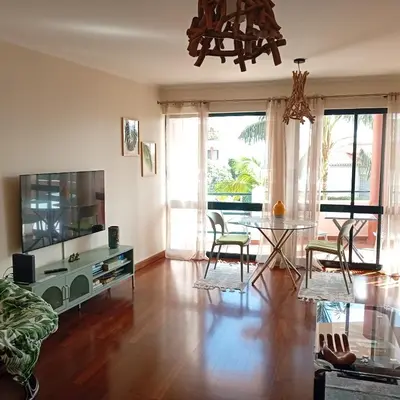 a living room with a television and a table and chairs at Varandas do Funchal Apartment in Funchal