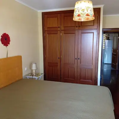 a bedroom with a bed and a chandelier at Varandas do Funchal Apartment in Funchal