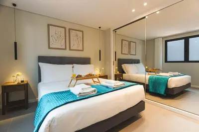 a bedroom with two beds and a mirror at Ninho Memory in Funchal