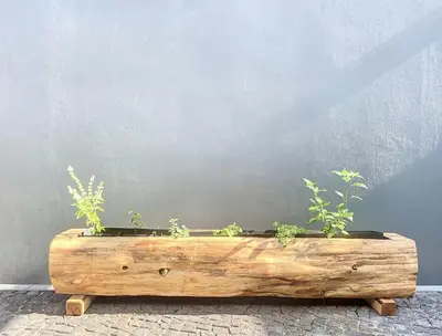 a wooden planter with plants in it next to a wall at Ninho Memory in Funchal