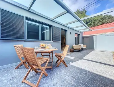 a patio with a wooden table and chairs at Ninho Memory in Funchal