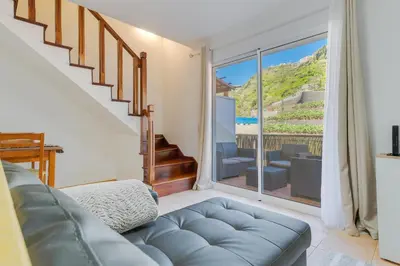 a living room with a couch and a large window at Villa Holiday Sun by Holiday Rental Madeira in Ponta do Sol