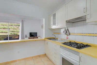 a kitchen with white cabinets and a stove top oven at Villa Holiday Sun by Holiday Rental Madeira in Ponta do Sol