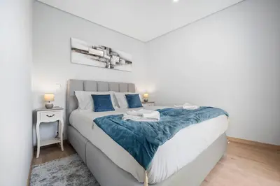 a bedroom with a large bed with blue pillows at Atlantic View Studio in Ponta Delgada