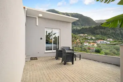 a balcony with two chairs and a table and a window at Atlantic View Studio in Ponta Delgada