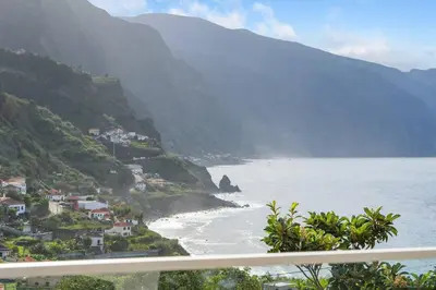a view of a beach with houses and mountains at Atlantic View Studio in Ponta Delgada