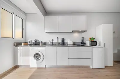 a white kitchen with a washing machine in it at Atlantic View Studio in Ponta Delgada