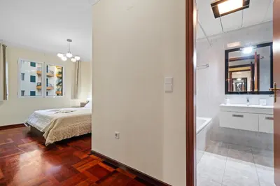 a bedroom with a bed and a bathroom with a sink at Famoso Grand Stay - Free Parking in Funchal