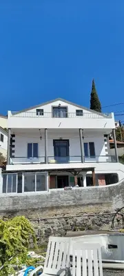 a building with two white chairs in front of it at Sea view 2 bedrooms terrace Villa in Funchal