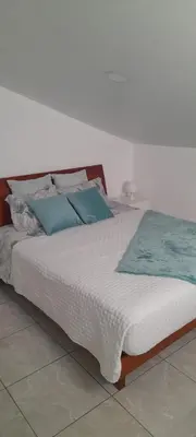 a large white bed with blue pillows on it at Sea view 2 bedrooms terrace Villa in Funchal