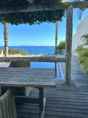 a wooden deck with a table and chairs and the ocean at Santa Cruz Ocean Villa in Gaula