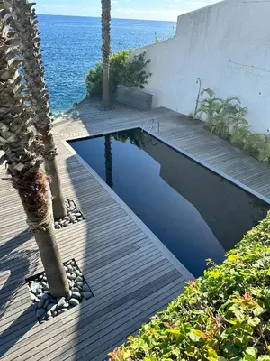 a swimming pool on a deck next to the ocean at Santa Cruz Ocean Villa in Gaula