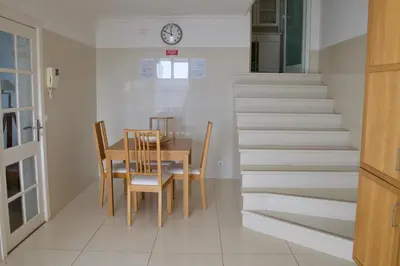 a dining room and stairs with a table and chairs at Santa Cruz Ocean Villa in Gaula