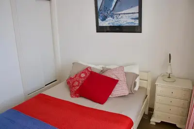 a bedroom with a bed with red and blue pillows at Santa Cruz Ocean Villa in Gaula