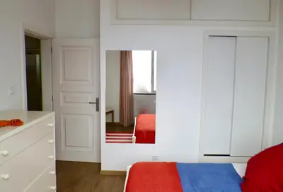 a bedroom with a mirror and a bed and a red chair at Santa Cruz Ocean Villa in Gaula