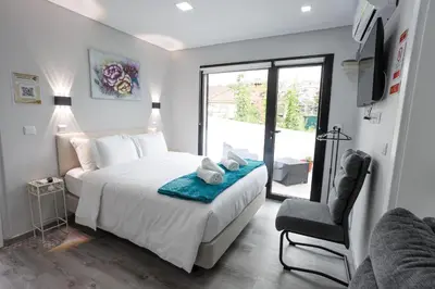a bedroom with a bed and a chair and a window at Casa da Mãe in Santana