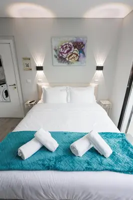 a bedroom with a white bed with two towels on it at Casa da Mãe in Santana