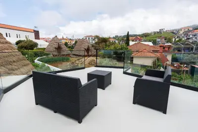 a balcony with a table and chairs on a roof at Casa da Mãe in Santana
