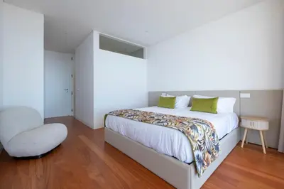 a bedroom with a large bed and a chair at Villa Rada, by Pausa Holiday Rentals in Estreito da Calheta
