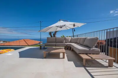 a couch and an umbrella on a roof at Villa Rada, by Pausa Holiday Rentals in Estreito da Calheta