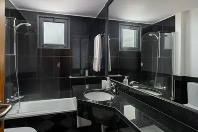 a black bathroom with two sinks and a tub and a mirror at Blue Horizon Apartment by An Island Apart in Caniço