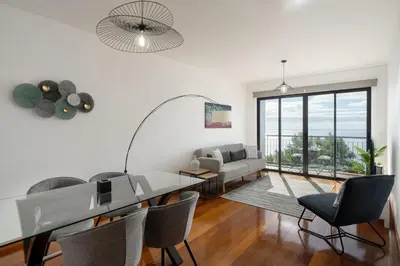 a white living room with a dining table and chairs at Blue Horizon Apartment by An Island Apart in Caniço