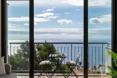a room with a view of the ocean from a balcony at Blue Horizon Apartment by An Island Apart in Caniço