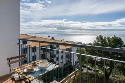 a balcony with a table and a view of the water at Blue Horizon Apartment by An Island Apart in Caniço