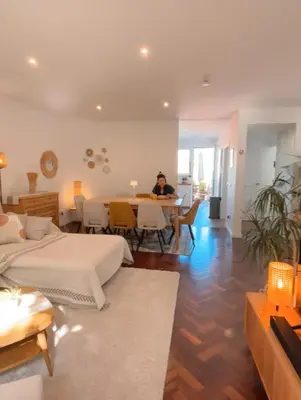a man sitting at a table in a room at The Luzia House - 4BR Villa - AC, large kitchen, living room, free parking, gardens, terraces, sun exposure all day - Coliving in Funchal