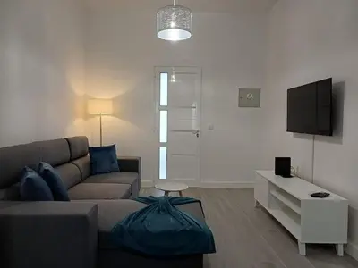 a living room with a couch and a tv at Sunset Cottage in Ponta do Sol