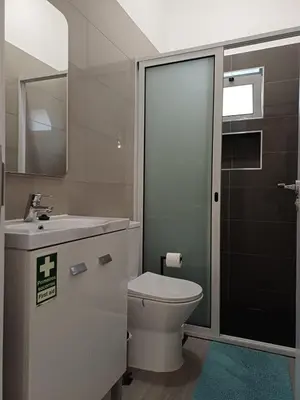 a bathroom with a toilet and a sink and a mirror at Sunset Cottage in Ponta do Sol